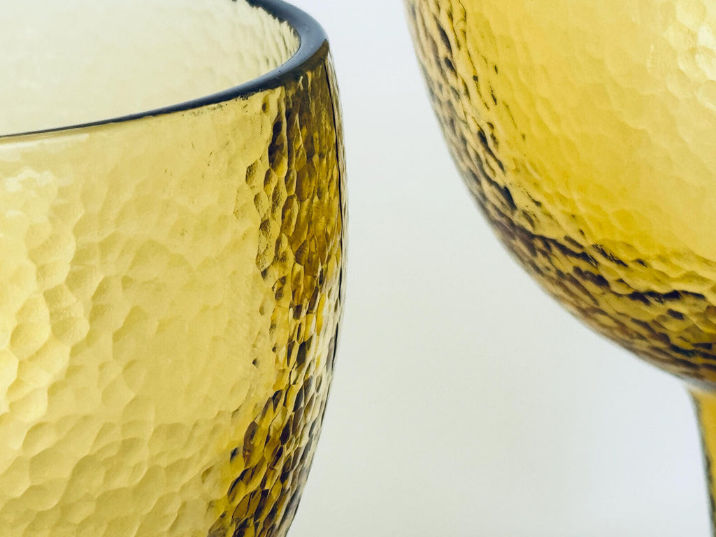 Close-up detail of textured amber glass bowl showing bubbled pattern and clarity