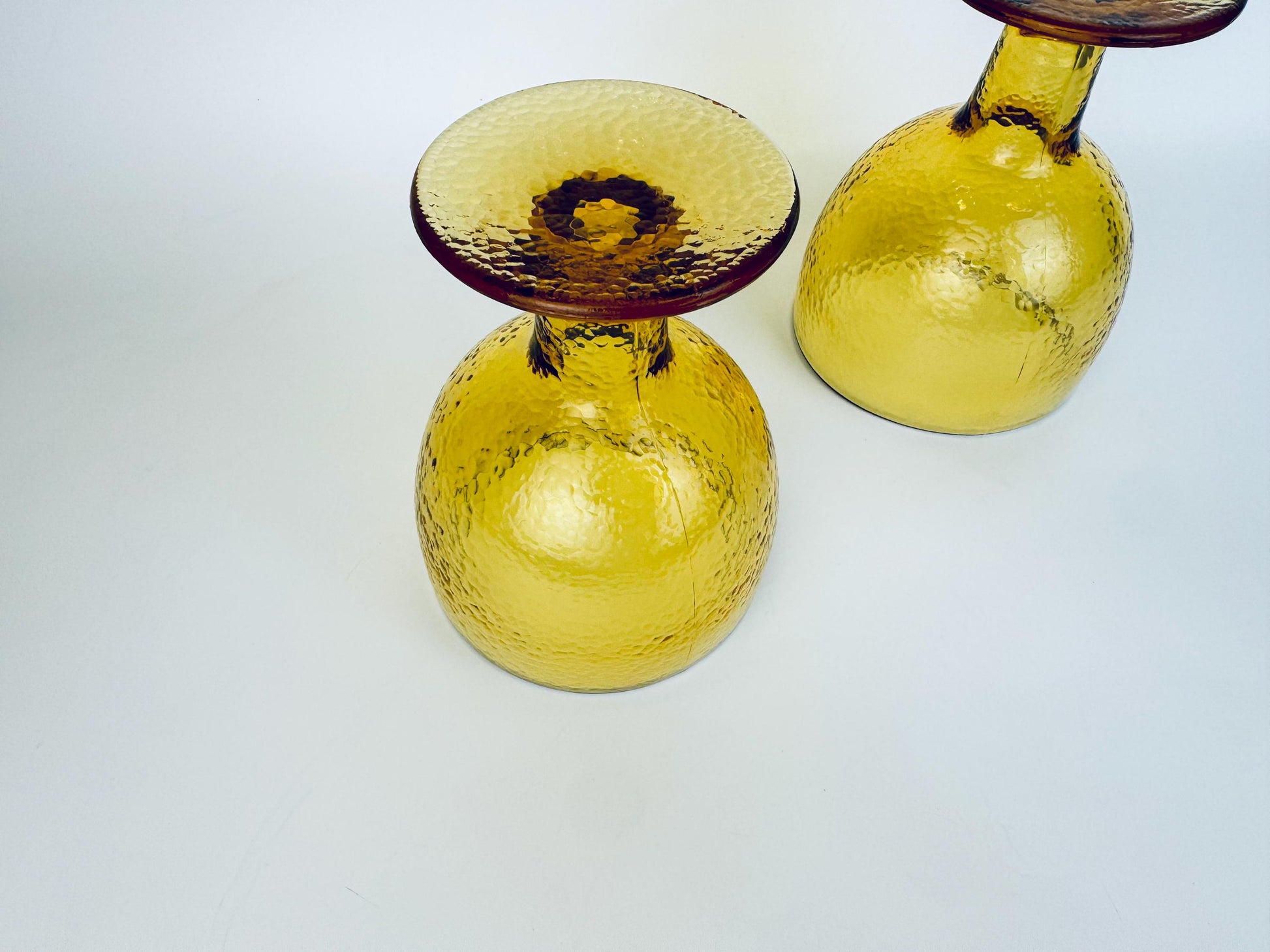 Two amber goblets upright with textured stems and bowls catching the light