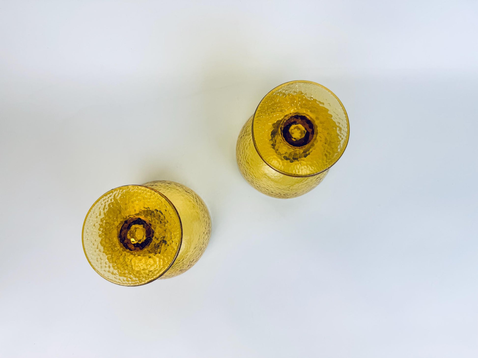 Overhead view of amber goblets showing wide circular bases and rich colour tone