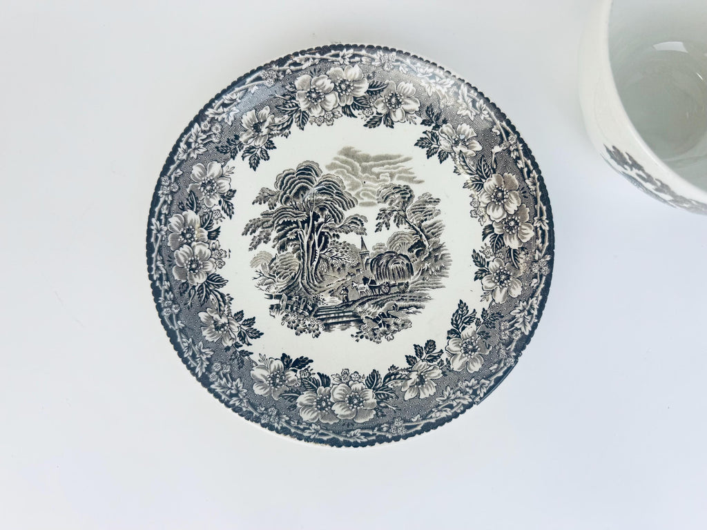 Overhead view of Woodland saucer by Enoch Wedgwood showing black transferware countryside scene with floral border pattern