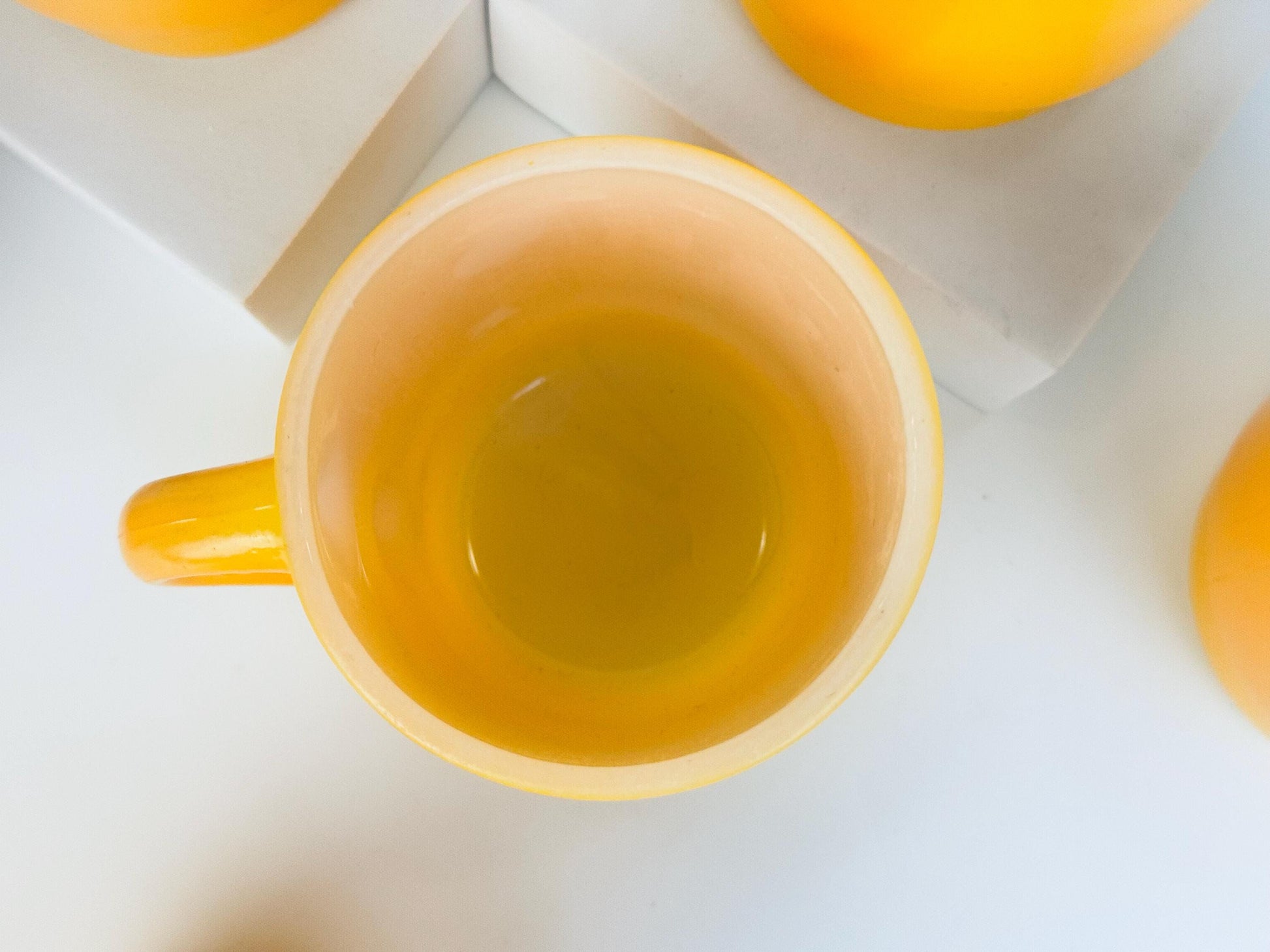 Yellow mug with tea on a white background
