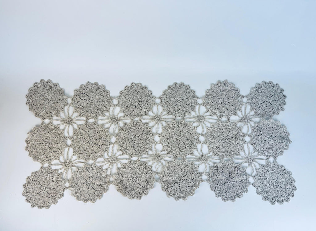 Crocheted doily with floral pattern on a light blue background