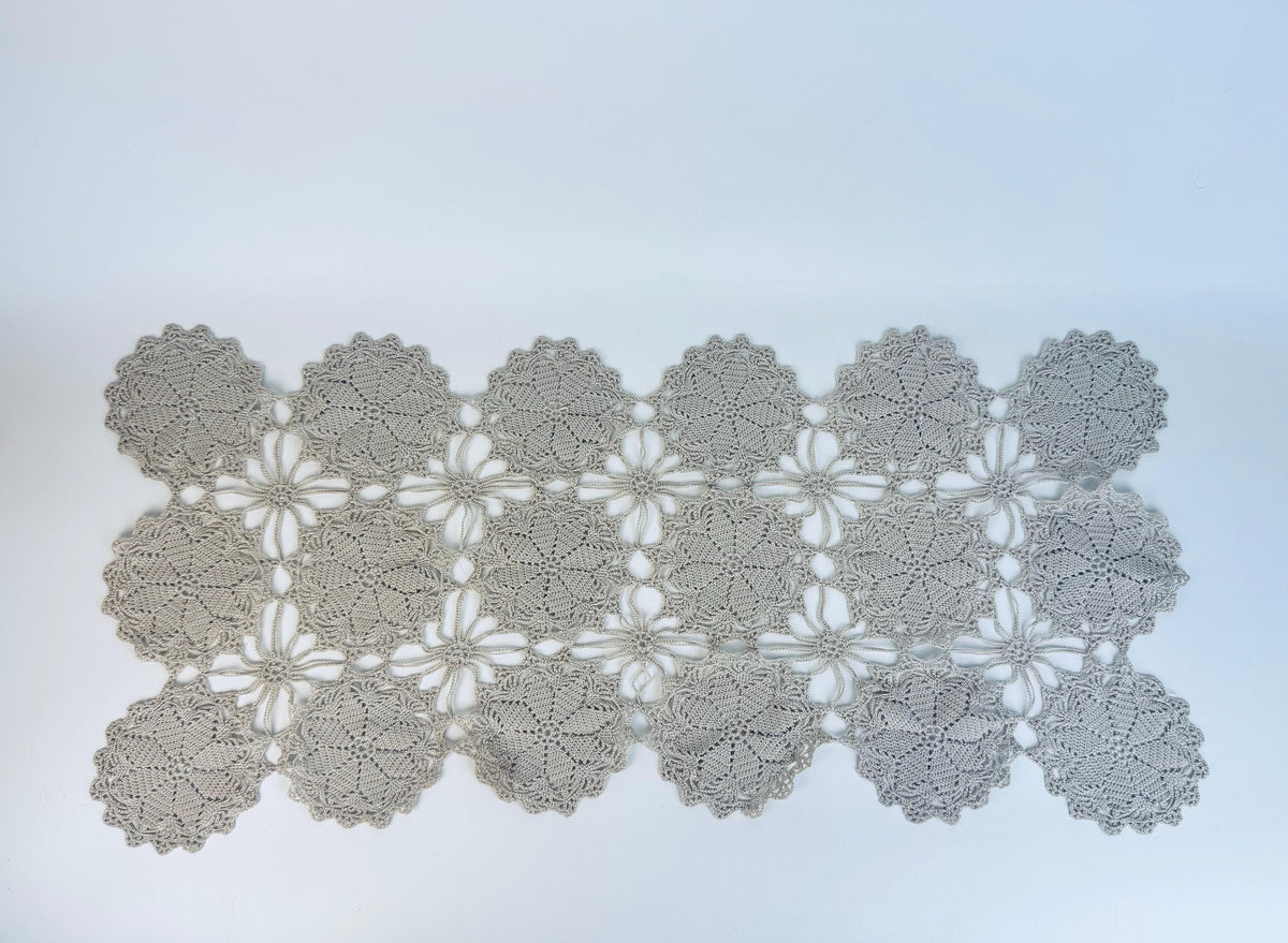 Crocheted doily with floral pattern on a light blue background