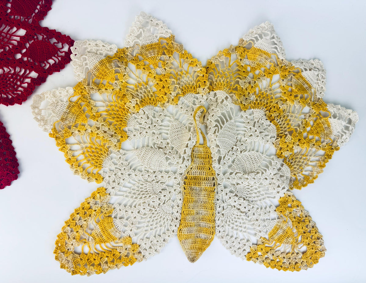 Close-up of yellow butterfly doily from top angle, showing body and lace wings