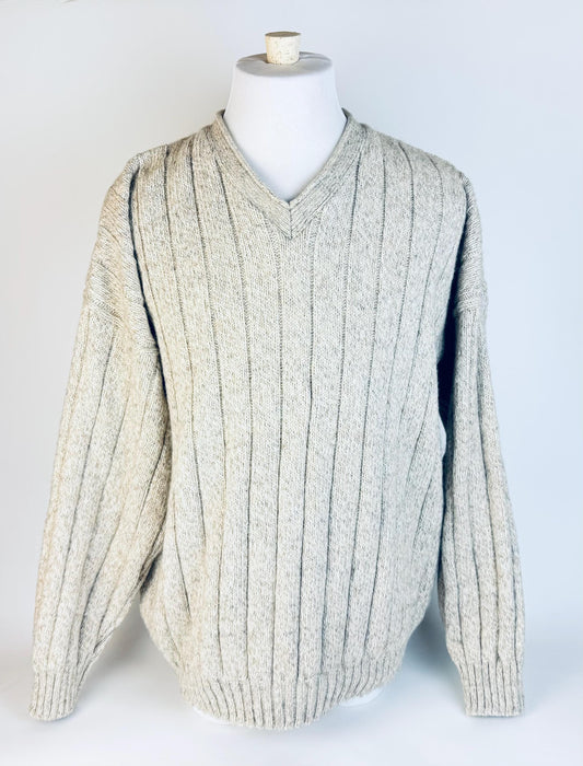 Beige ribbed sweater on a mannequin against a white background