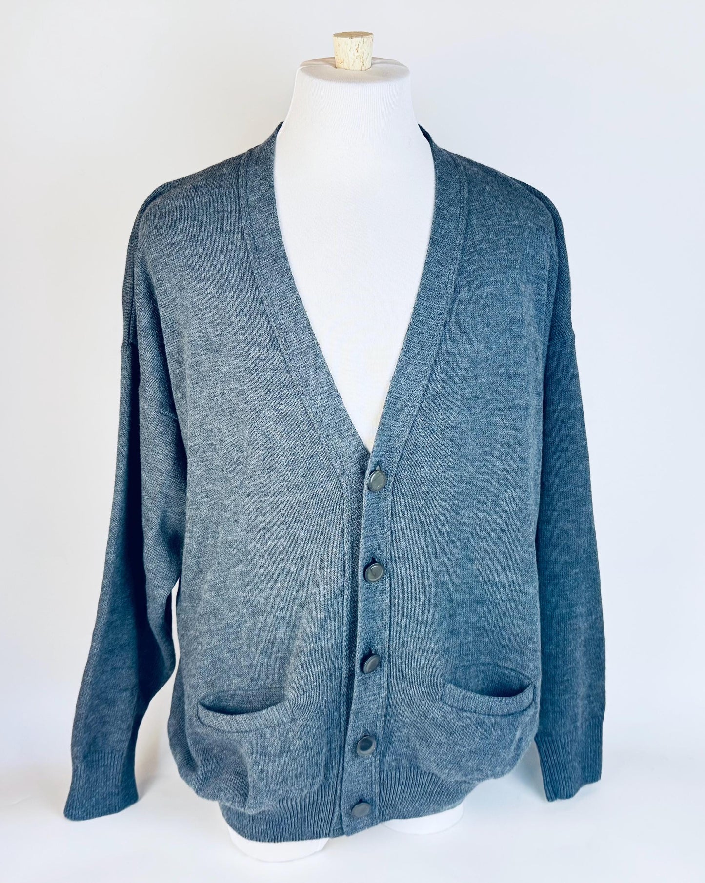 Grey cardigan on a mannequin against a white background