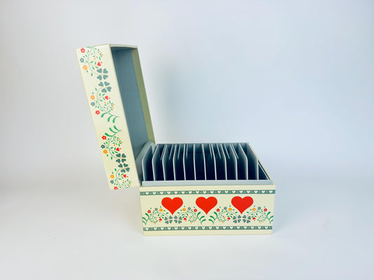 Decorative box with floral patterns and red hearts on a light gray background