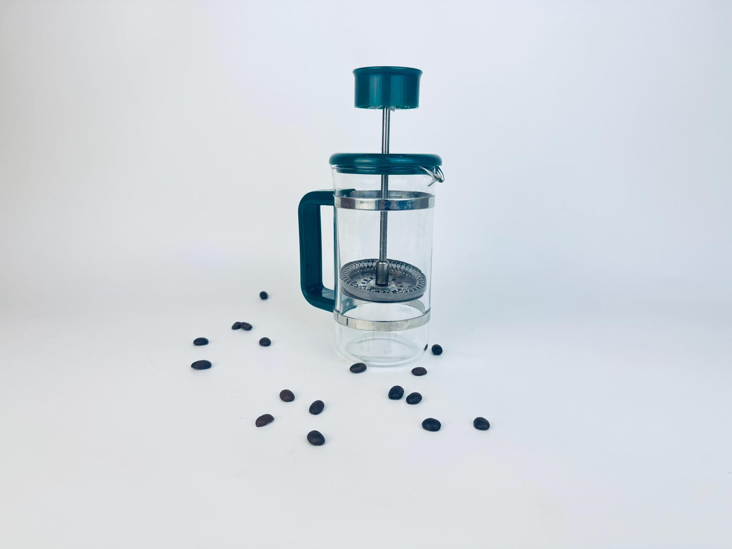 French press coffee maker with coffee beans on a white background