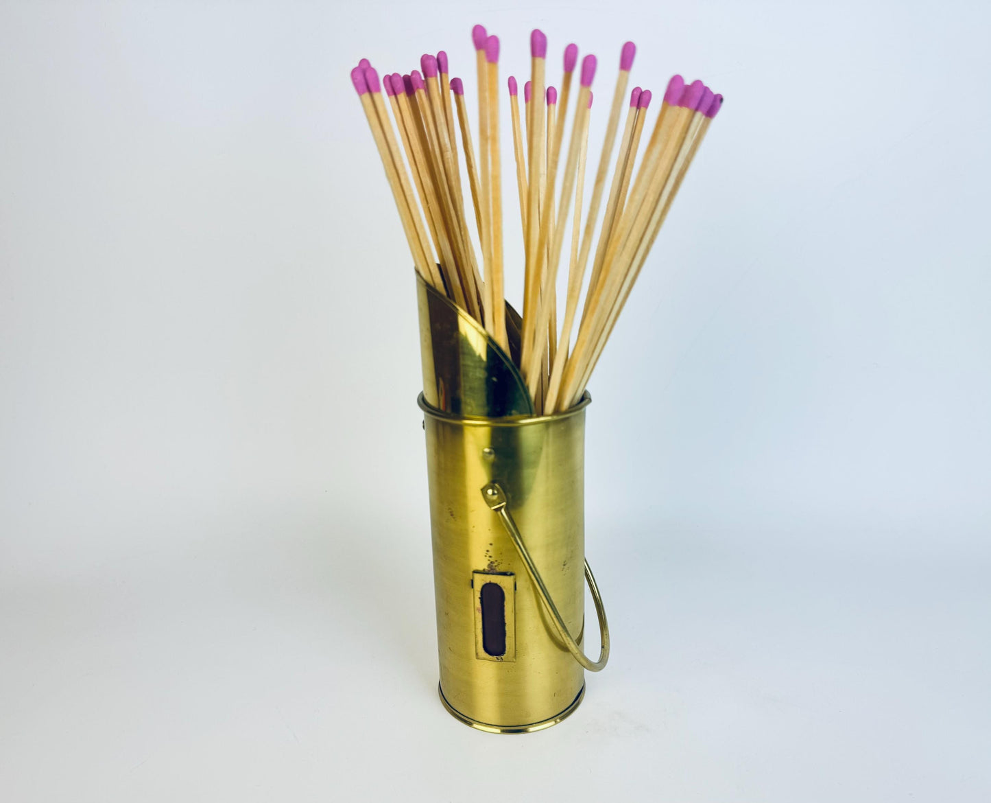 Gold matchstick holder with matches on a white background