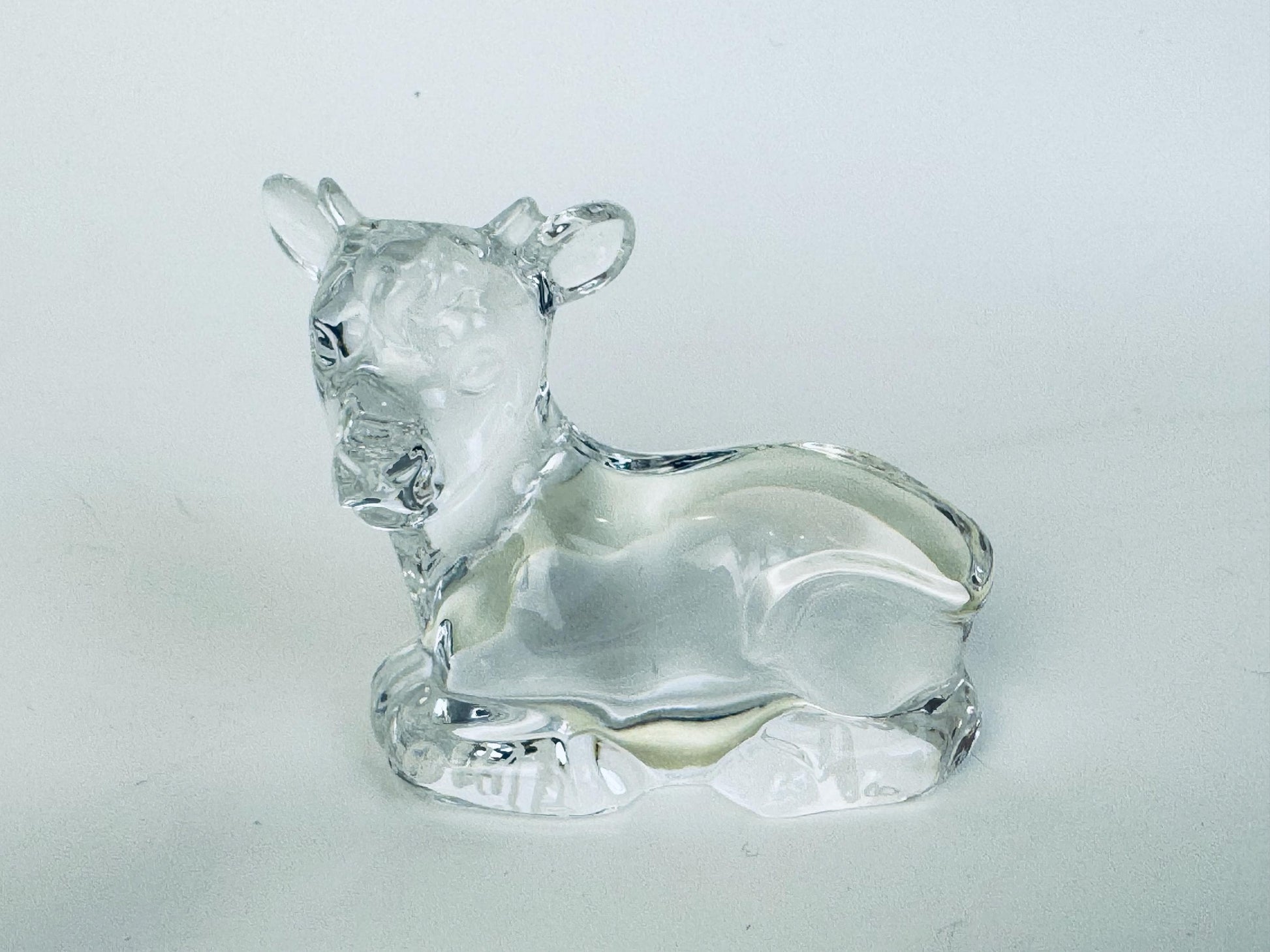 “Crystal cow figurine from Marquis by Waterford nativity animals, lying down with smooth and faceted surfaces.