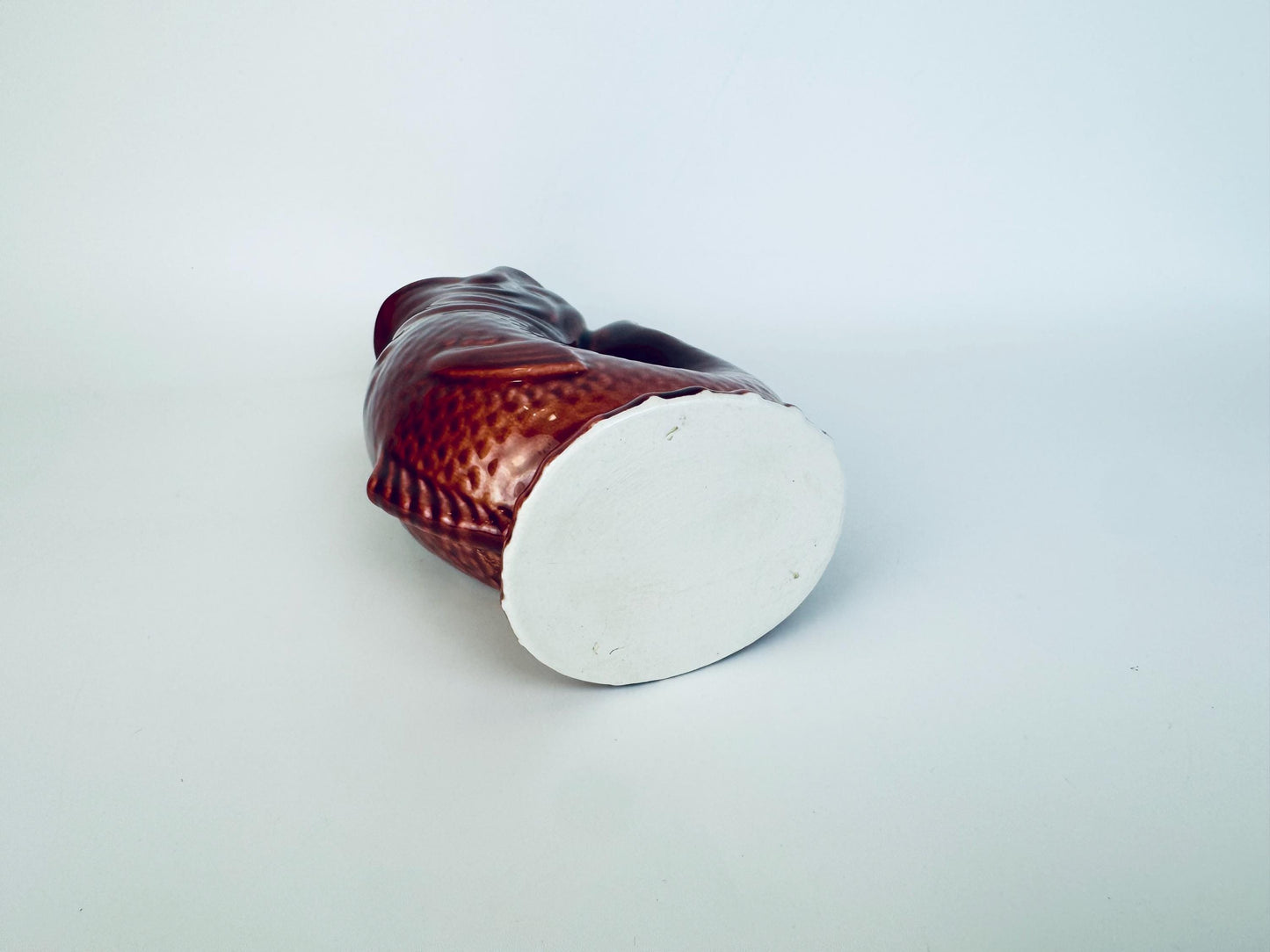 Bottom view of vintage ceramic fish pitcher showing unglazed base and glaze finish around edges