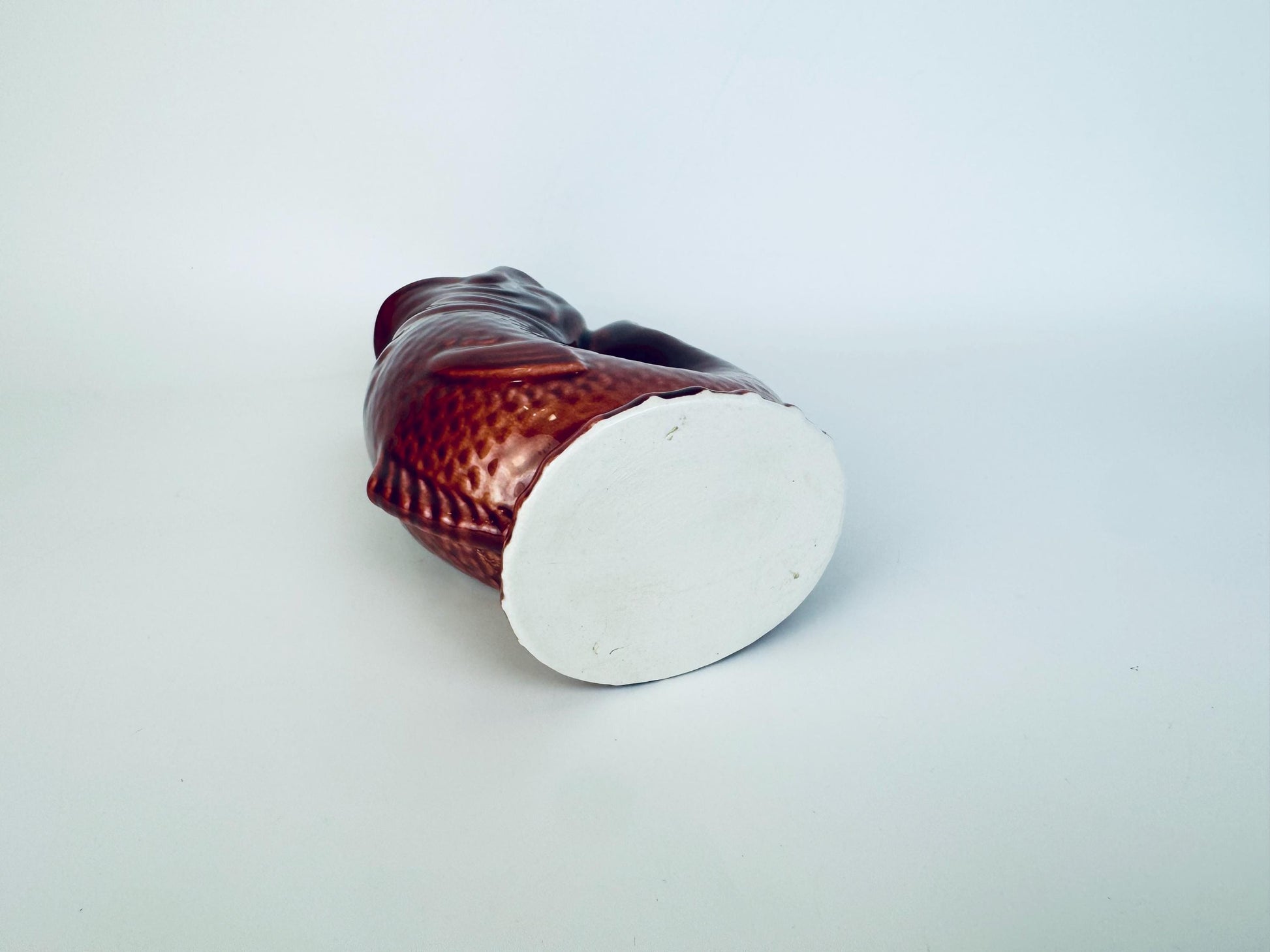 Bottom view of vintage ceramic fish pitcher showing unglazed base and glaze finish around edges