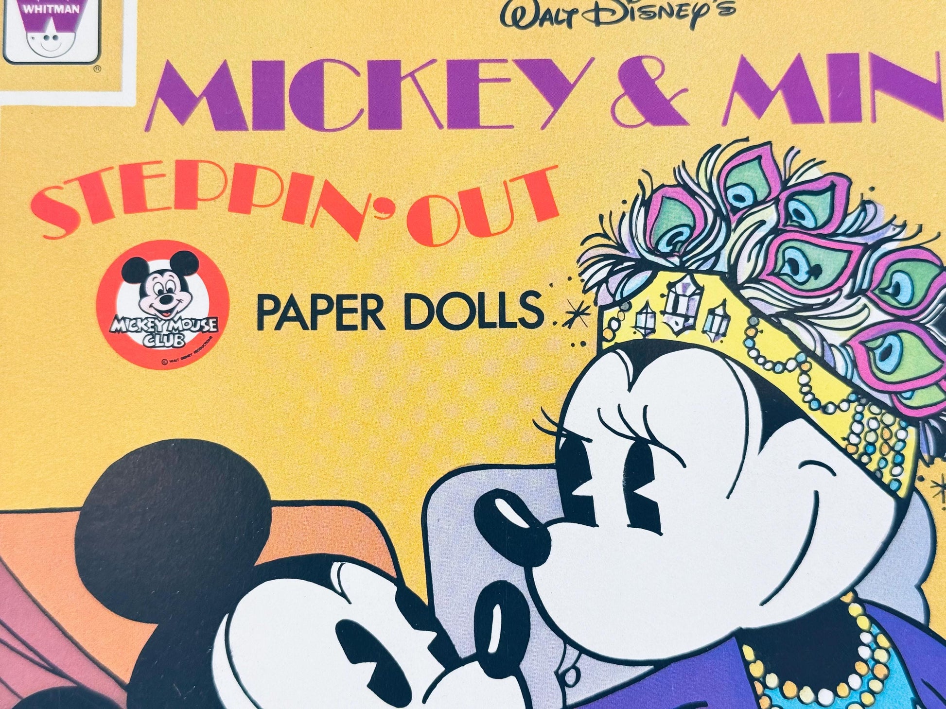 Detailed view of Mickey and Minnie character artwork from paper doll book cover