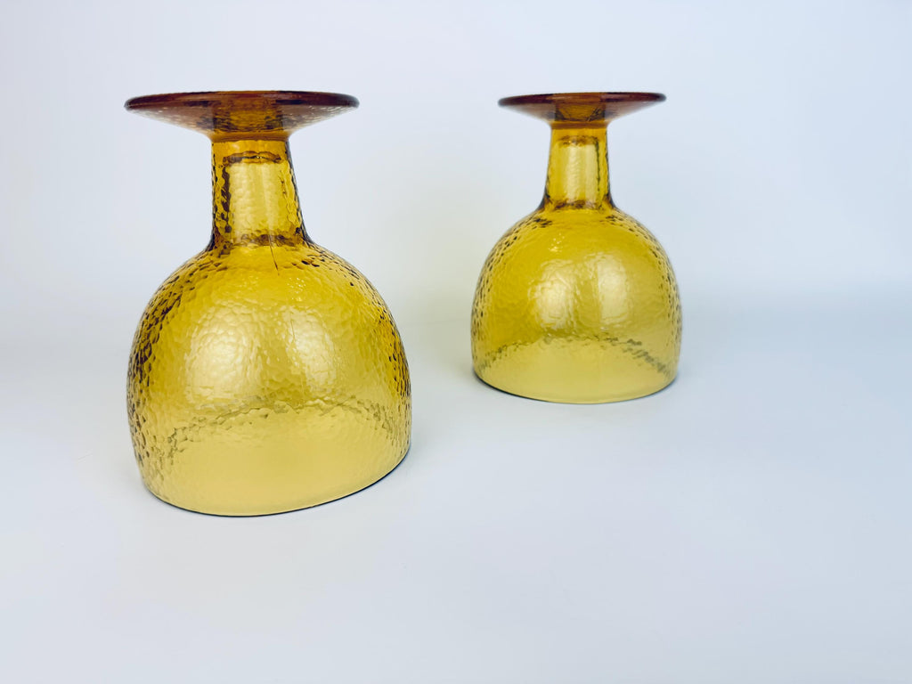 Amber goblets angled on their sides, showing base detail and textured glass pattern