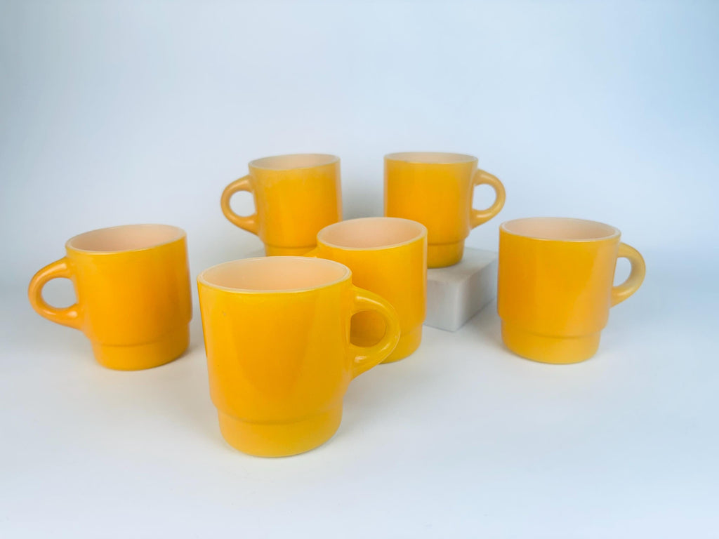Set of six yellow mugs on a white background