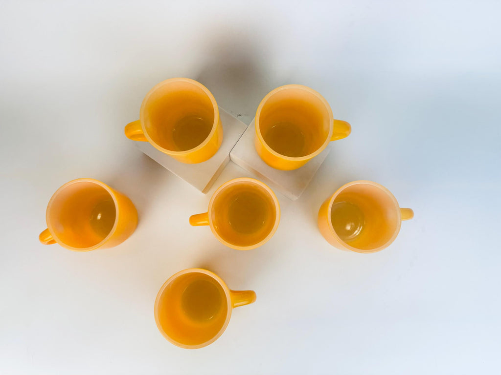 Set of six yellow mugs on a white background
