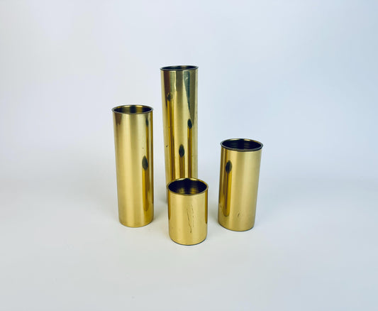 Set of four vintage brass cylinder candle holders in varying heights, made in Portugal, displayed on a white background.