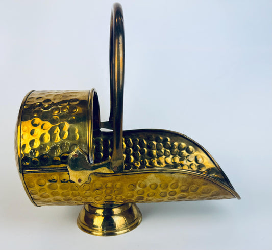 Vintage hammered solid brass coal scuttle with curved spout, pedestal base, and arched handle.