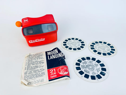 Vintage red GAF View-Master with three Apollo 11 Moon Landing reels and original sleeve dated July 21, 1969, displayed on a white background.