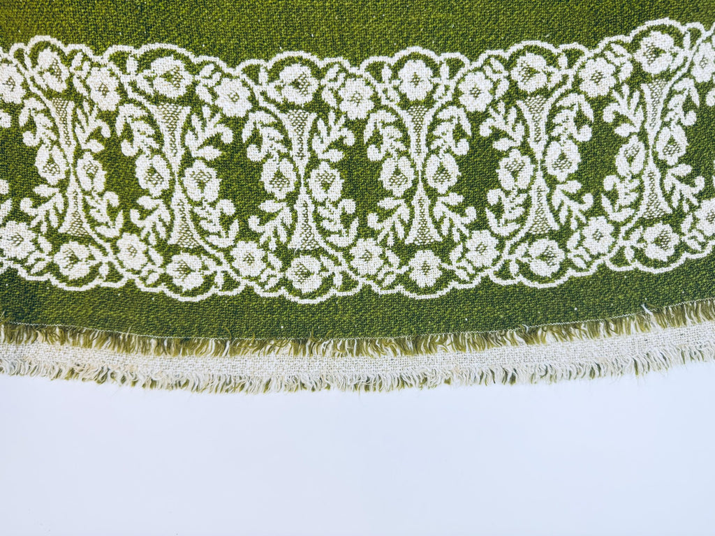 Decorative lace trim with floral patterns on a green fabric background