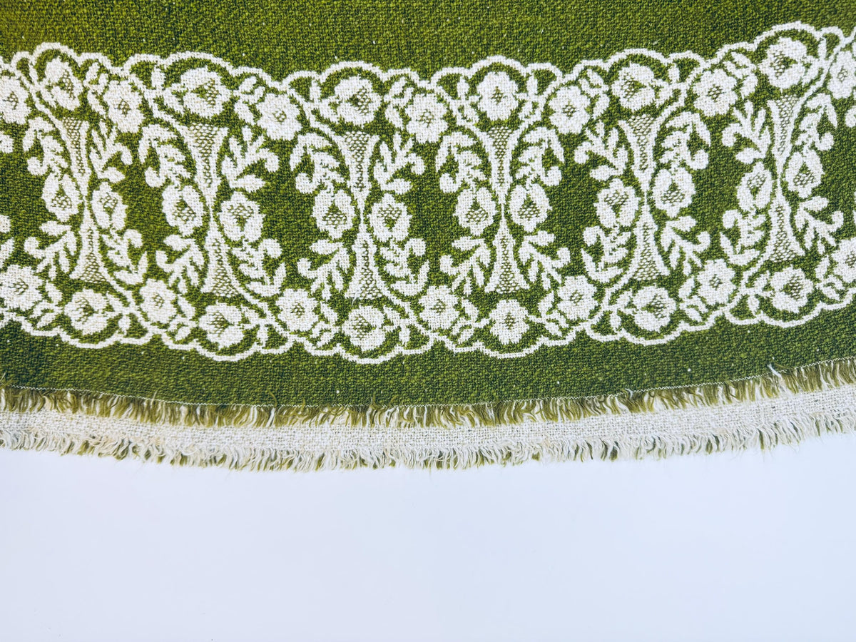 Decorative lace trim with floral patterns on a green fabric background