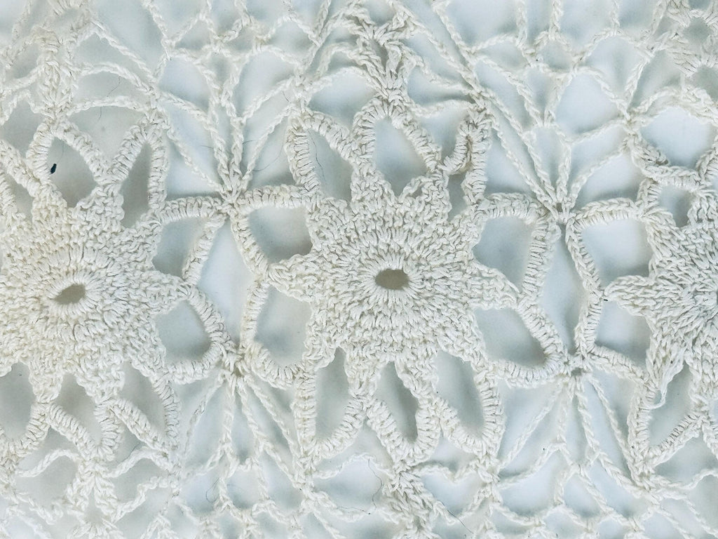Detailed view of ivory starburst lace pattern at centre of runner