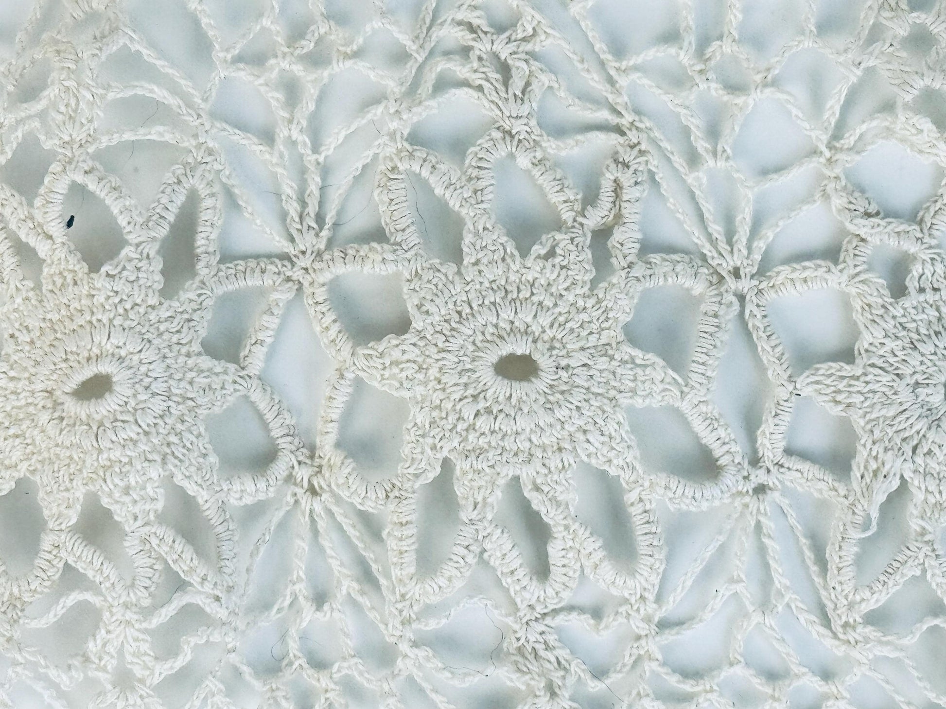 Detailed view of ivory starburst lace pattern at centre of runner