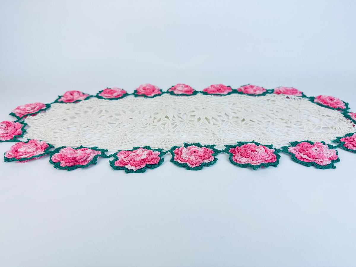 Side angle of full crochet doily showing floral edge and oval shape