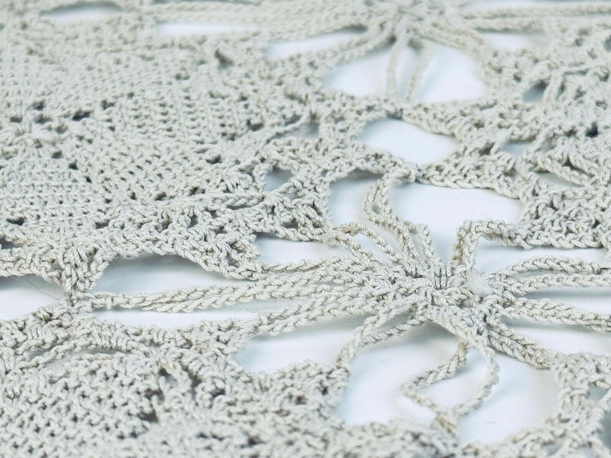 Macro detail showing interwoven cotton threads and openwork design