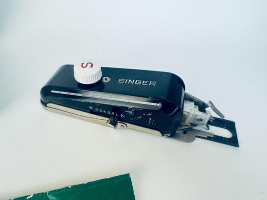 Vintage 1950s Singer Buttonholer Model 160506 sewing machine attachment in black metal with a white “S” control knob, shown with metal components and mounting plate for low-shank machines.