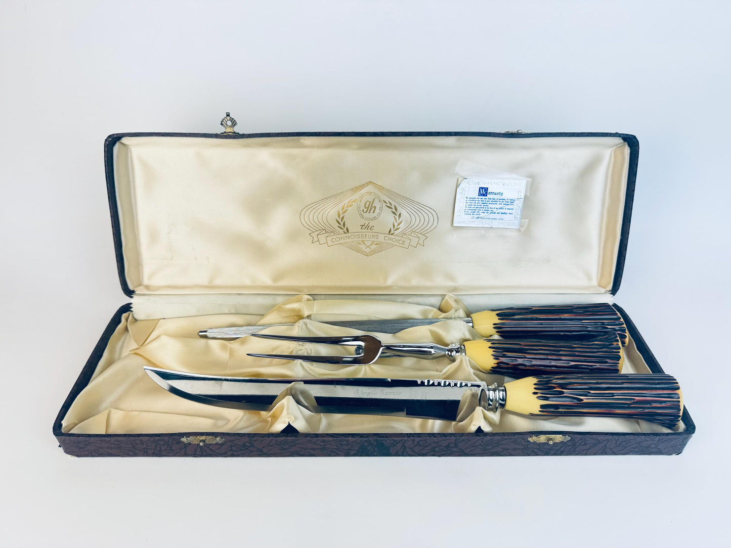 Vintage 1960s Glo-Hill carving set with faux-antler Bakelite handles and Sheffield steel blades displayed in satin-lined Connoisseurs Choice case.