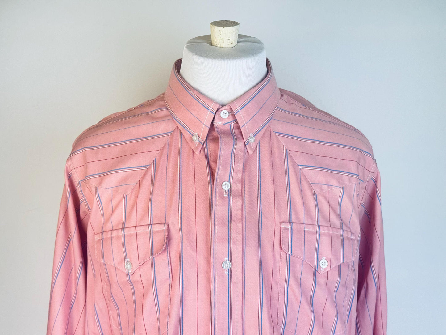 Pink striped shirt on a mannequin against a white background