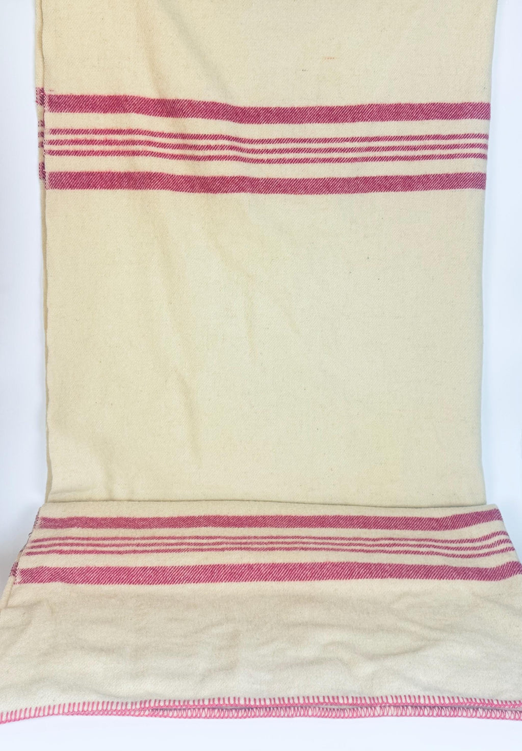 Vintage Brandon Woollen Mills beige wool blanket with bold pink stripes, laid flat to show full pattern and stitched edging detail.