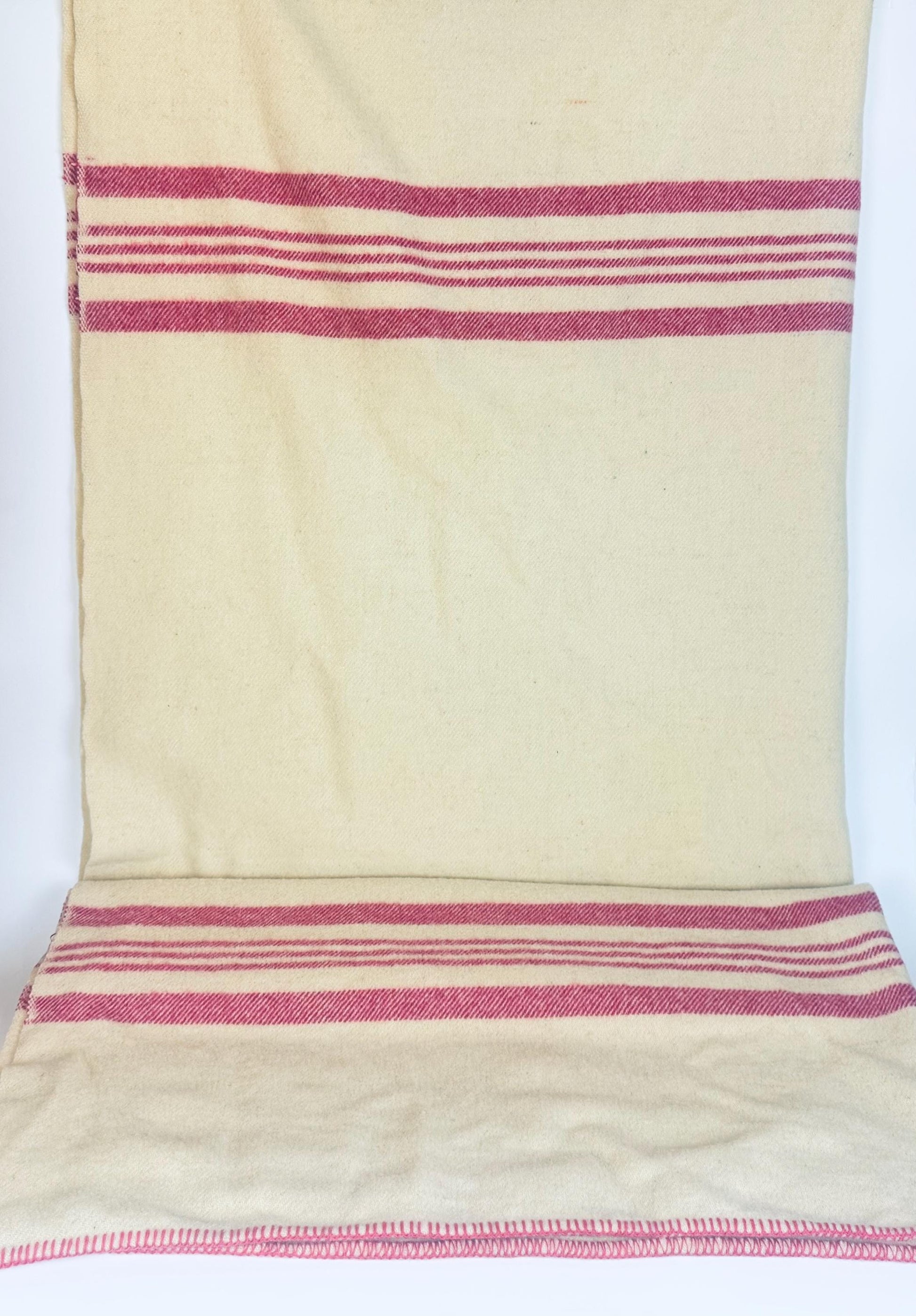 Vintage Brandon Woollen Mills beige wool blanket with bold pink stripes, laid flat to show full pattern and stitched edging detail.