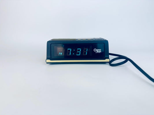 Digital clock with blue LED display on a white background