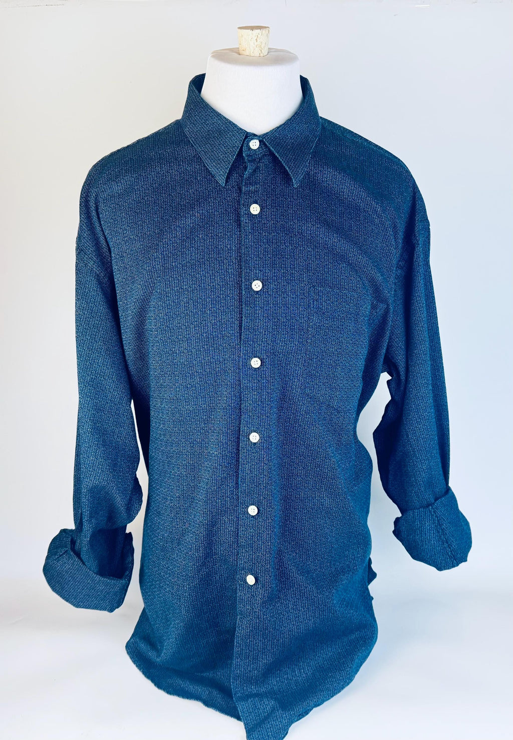 Blue button-up shirt on a mannequin against a white background