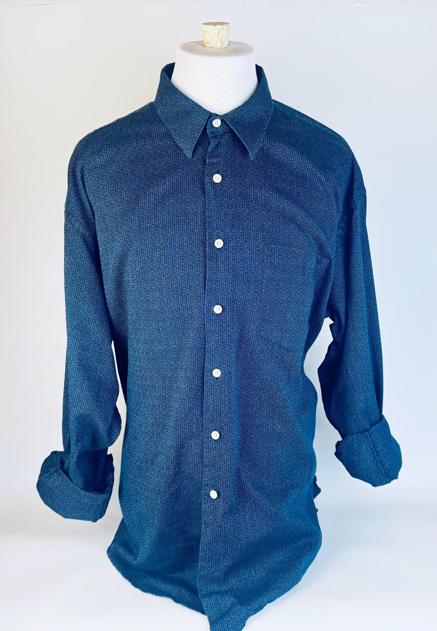 Blue button-up shirt on a mannequin against a white background