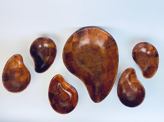 Set of teardrop shaped wooden bowls on a white background