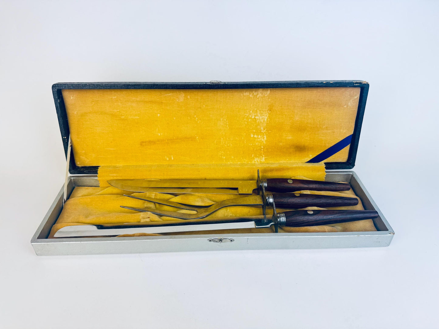 Vintage 1960s three-piece carving set made in Japan, featuring stainless steel blades and smooth rosewood handles, displayed in its original yellow satin-lined presentation box for holiday serving.