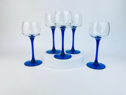 Set of five wine glasses with blue stems on a white background