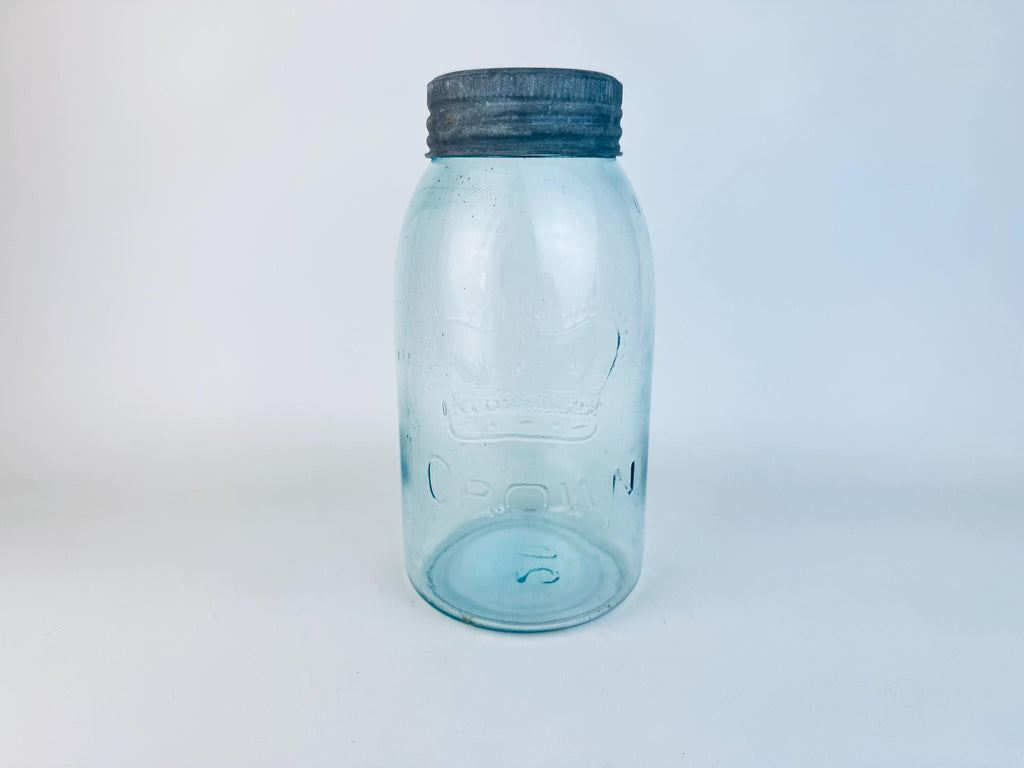 CROWN light blue glass jar with a dark lid on a light gray background