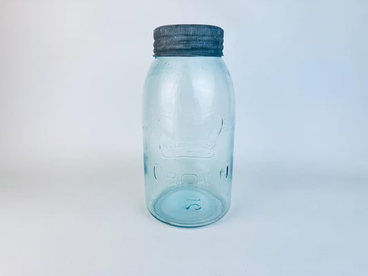 CROWN light blue glass jar with a dark lid on a light gray background