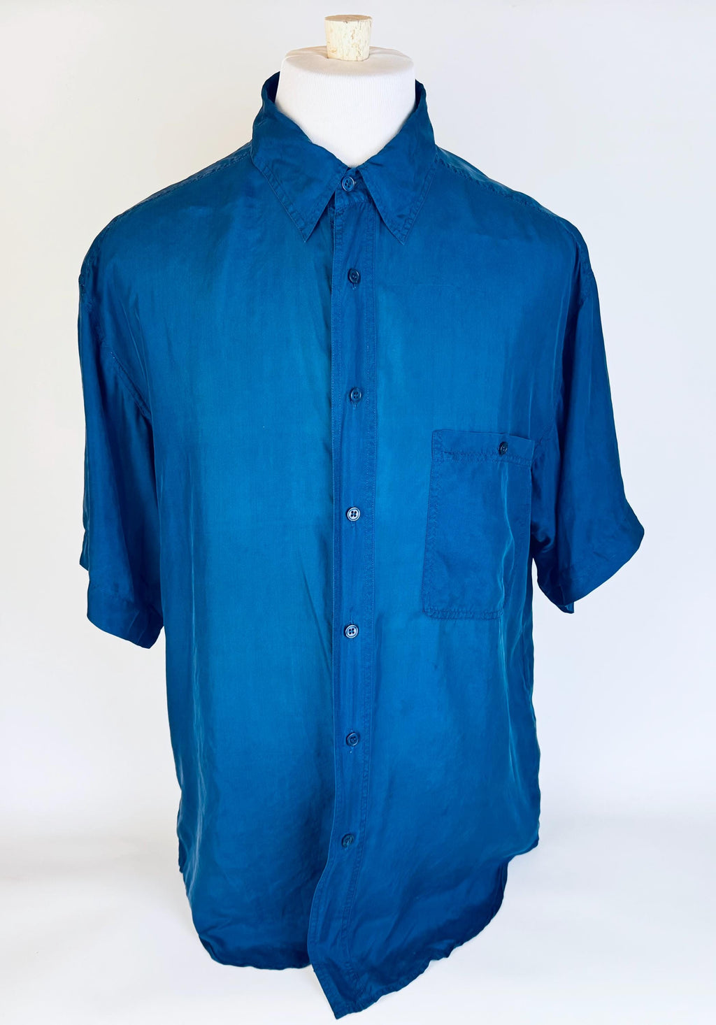 Blue silk mens shirt on a mannequin against a white background
