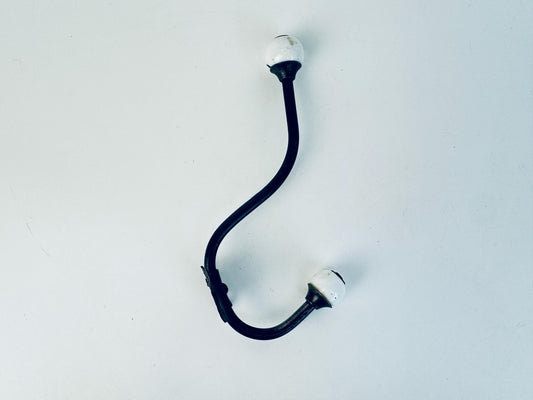 Antique black iron with white porcelain ends double wall hook. 