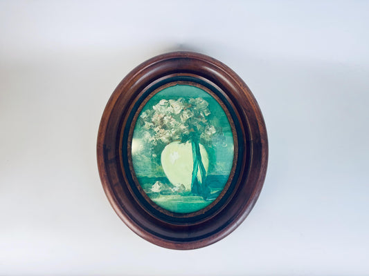Round wooden frame with a floral scenic print on a white background