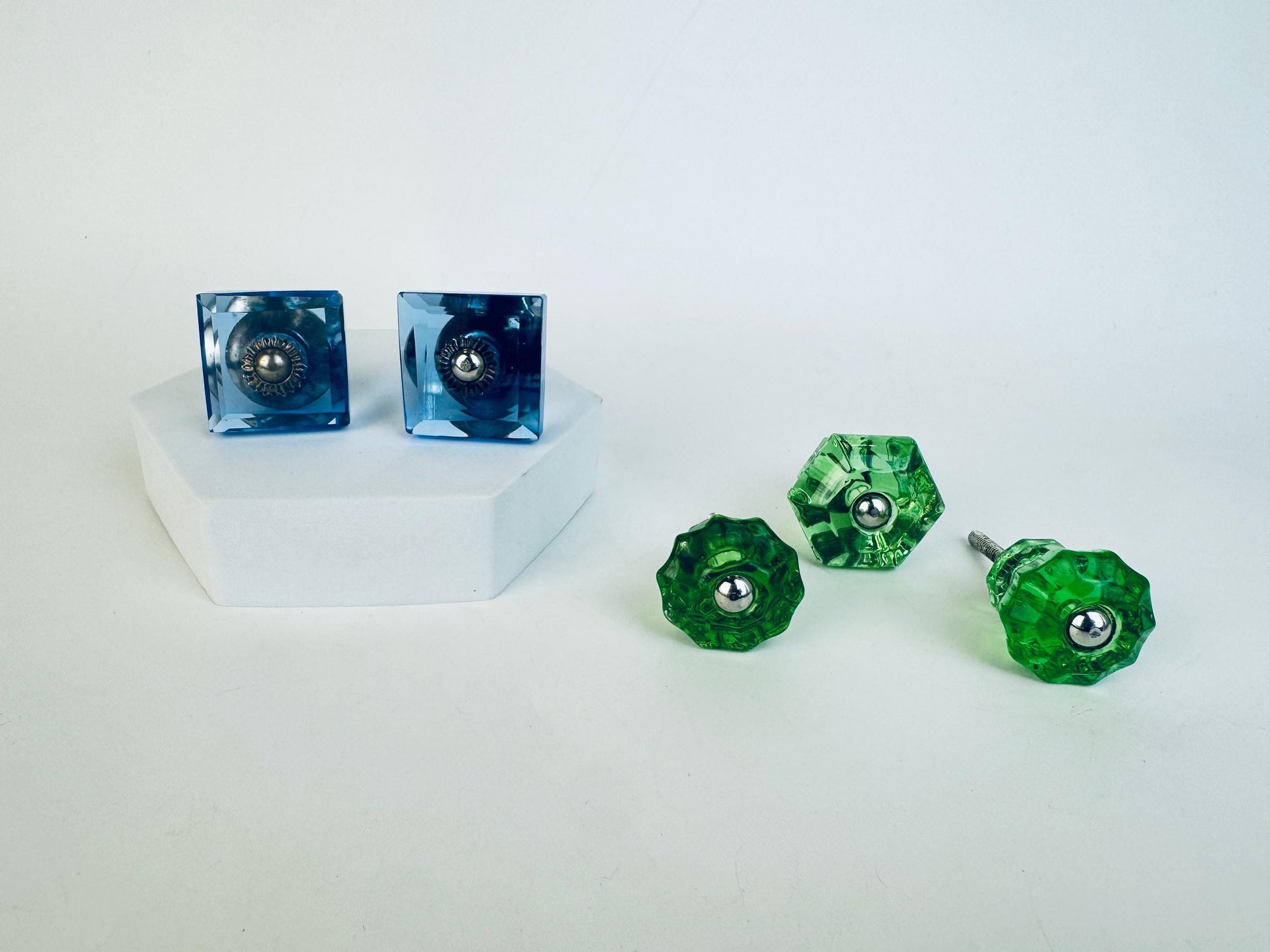 Set of blue and green glass knobs on a white background