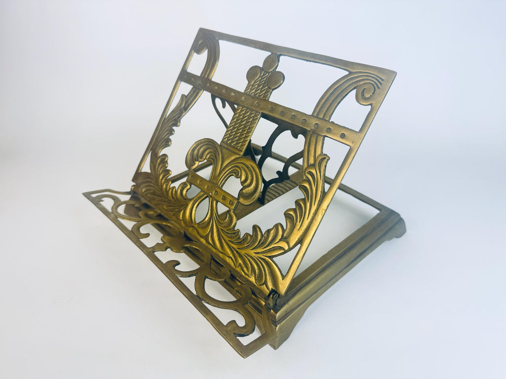 Decorative brass book stand on a white background