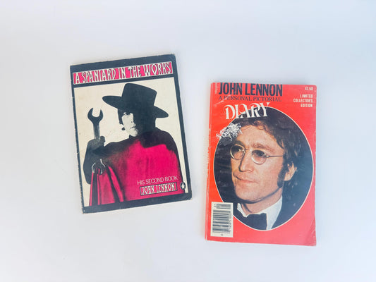 Two vintage John Lennon books displayed side by side on a white background — A Spaniard in the Works featuring a stylized photo of Lennon in a black hat and red cloak holding a wrench, and John Lennon: A Personal Pictorial Diary with a red cover and portrait of Lennon wearing glasses and a tuxedo.