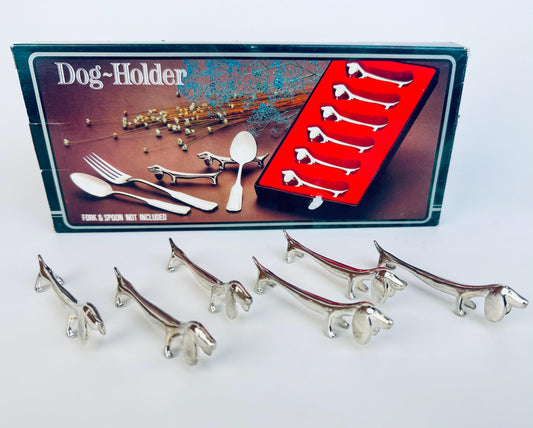 Metal dog-shaped holders with a packaging box featuring images of similar holders.