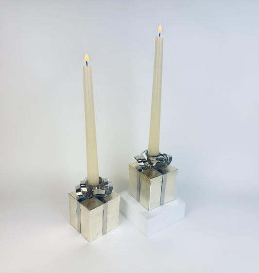 Two silver gift box candle holders with candles on a white background